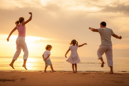 Happy-beautiful-family-dancing-on-the-beach-on-the-dawn-time